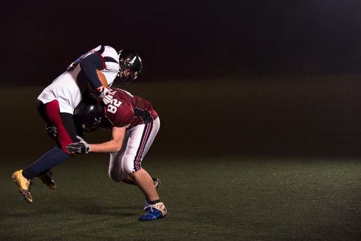 American football players in action at night game time on the field