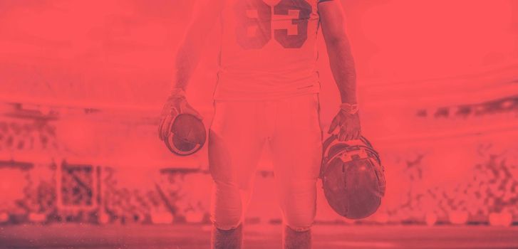 Closeup Portrait of a strong muscular American Football Player on big modern stadium field with lights and flares