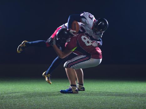 American football players in action at night game time on the field