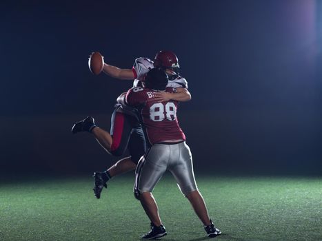 American football players in action at night game time on the field