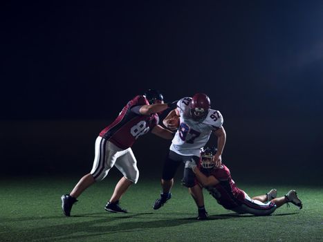 American football players in action at night game time on the field