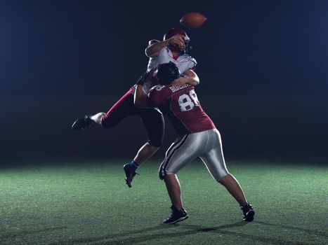 American football players in action at night game time on the field