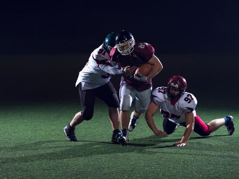 American football players in action at night game time on the field