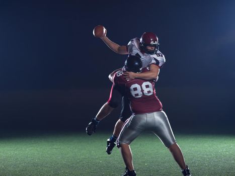 American football players in action at night game time on the field