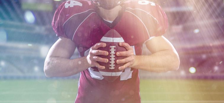 Closeup Portrait of a strong muscular American Football Player on big modern stadium field with lights and flares