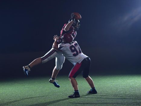 American football players in action at night game time on the field