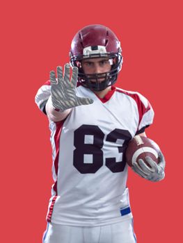 portrait of confident American football player holding ball isolated on colorful background