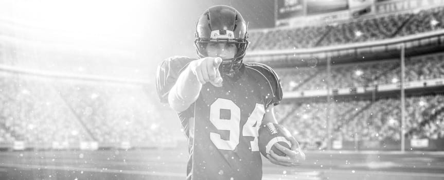 portrait of confident American football player holding ball while standing on field at night