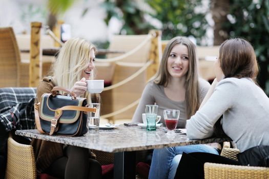 very cute smiling women drinking a coffee sitting inside in cafe restaurant