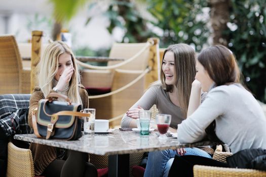 very cute smiling women drinking a coffee sitting inside in cafe restaurant