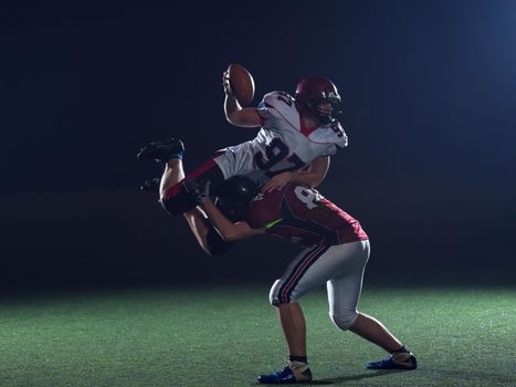 American football players in action at night game time on the field