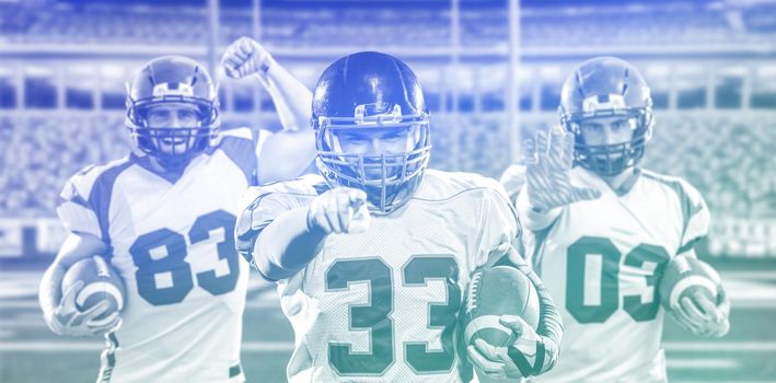 Portrait of American football player pointing against gray background