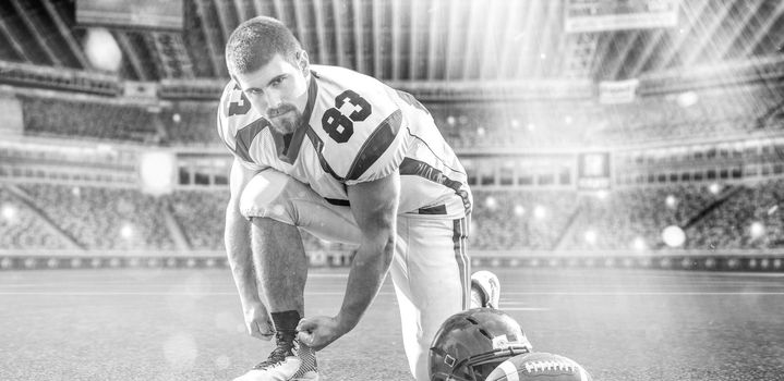 American Football Player preparing for match on big modern stadium field with lights and flares