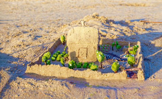 Beautiful sand castle illuminated by the morning sun on the beach of the tropical sea. The concept of a family vacation at sea.