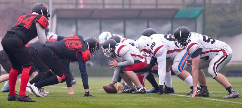 group of young professional american football players ready to start during training match on the stadium field