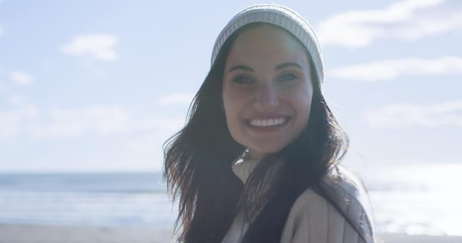 Portrait Of A Young Woman In Autumn Clothes Smiling On The Beach