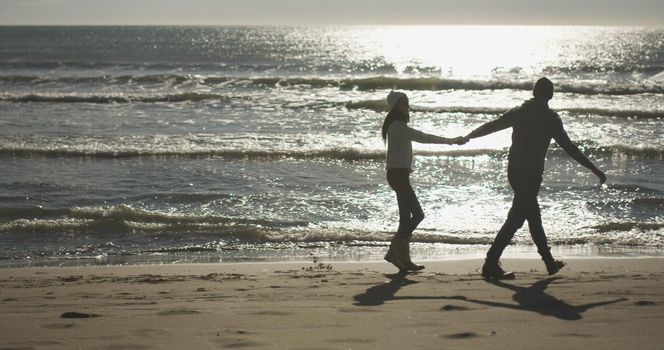 Romantic Couple Relaxing On The Beach during autumn day