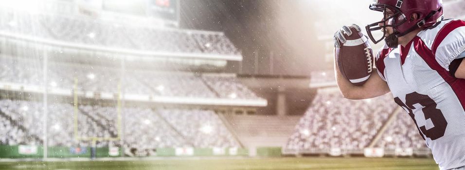 American football Player running with the ball isolated on big modern stadium field with lights and flares