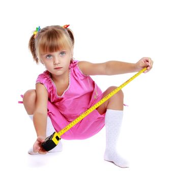 Cute little girl playing with a building tape. The concept of construction, advertising. Isolated on white background.