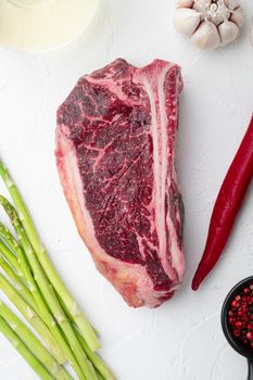 Raw fresh marbled meat black angus club steak and ingredients set, on white stone background, top view flat lay