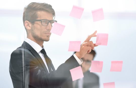 serious employee reads a sticker-note on the office Board.business concept