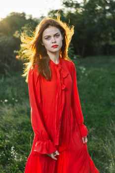 attractive woman in red dress outdoors in freedom field. High quality photo