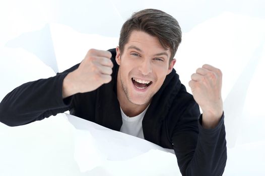 close up.purposeful young man, breaking through a paper wall.photo with copy space