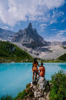 Lake Sorapis Italian Dolomites, Morning with clear sky on Lago di Sorapis in Italian Dolomites, lake with unique turquoise color water in Belluno province in Nothern Italy. couple in the mountains