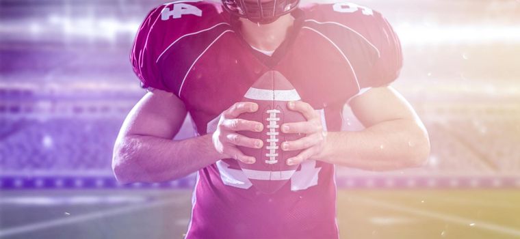 American Football Player isolated on big modern stadium field with lights and flares