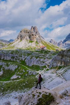 Tre Cime di Lavaredo peaks or Drei Zinnen at sunset, Dobbiaco Toblach, Trentino -Alto Adige or South Tyrol, Italy. Europe Alps. Asian woman hiking in the mountains