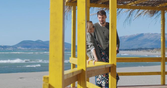 Happy couple enyojing time together on beach during autumn day