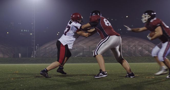 American football players in action at night game time on the field