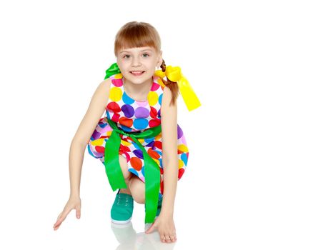 A happy little blonde girl with long pigtails, in which large colorful bows are braided, and a short bangs on her head. In a short summer dress, a pattern of multi-colored circles.