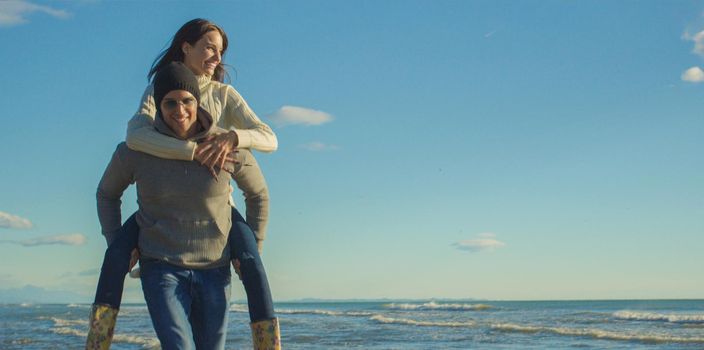 Men Giving Piggy Back Rides At Sunset By The Sea, autumn time