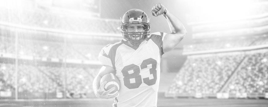 american football player celebrating touchdown on big modern stadium field with lights and flares