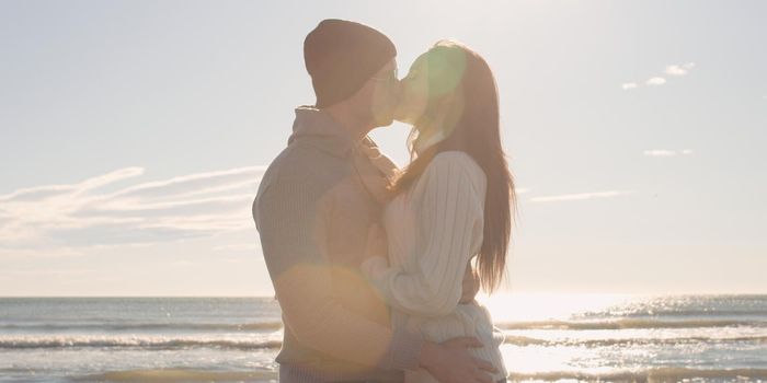 Cool Couple Laughing and hugging In Front Of Beach at beautiful autumn day