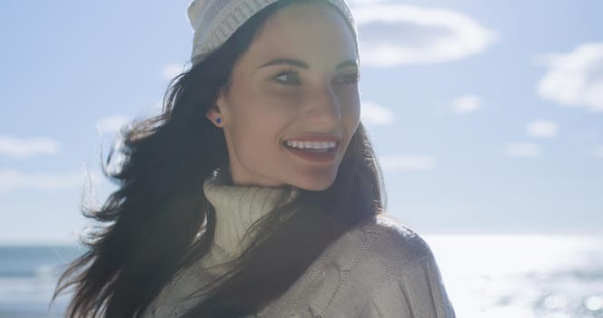 Portrait Of A Young Woman In Autumn Clothes Smiling On The Beach