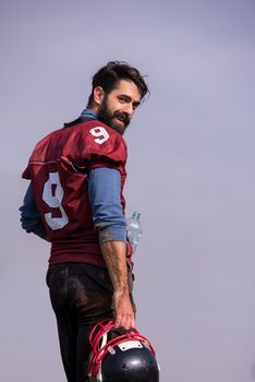 portrait of young confident American football player  standing on a field during the training
