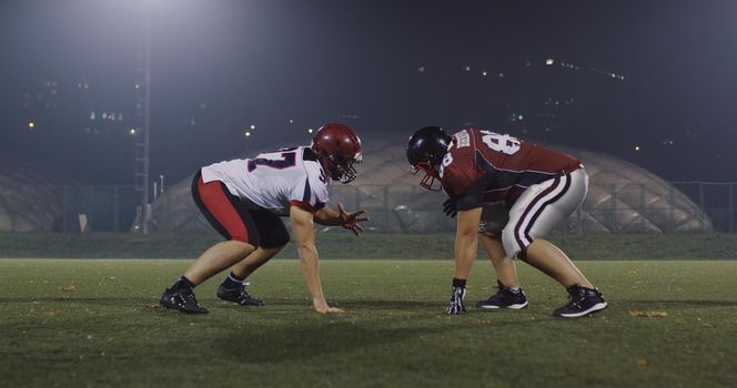 American football players in action at night game time on the field