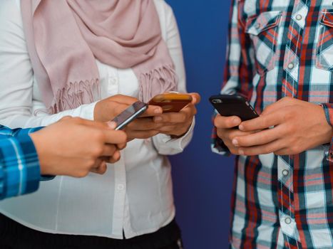 Arab teenagers group using smartphones for social media networking and sharing information for online education. Selective focus. High quality photo
