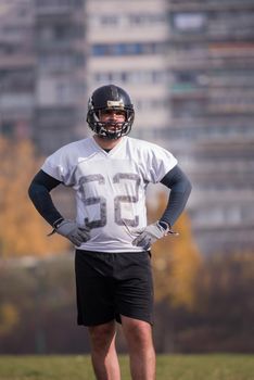 portrait of young confident American football player  standing on a field during the training