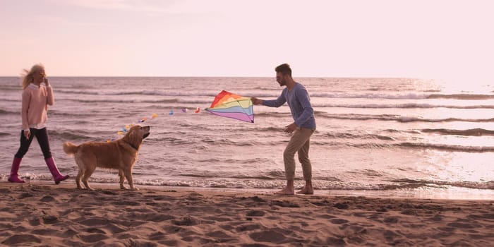 Couple Running On The Beach Holding Their Hands with dog On autmun day