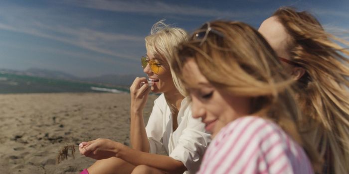 Group Of Young girlfriends Spending The Day On A Beach during autumn day