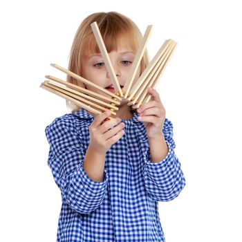 Cute little girl playing rattle. The concept of Russian folk instruments, music education. Isolated on white background.