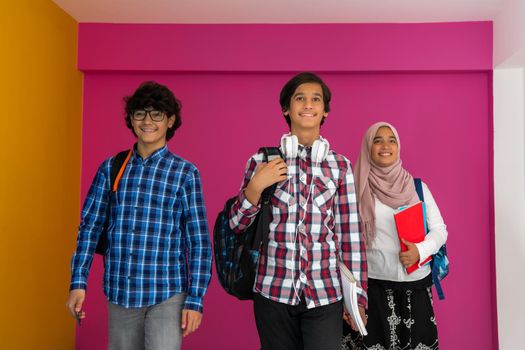 A group of Arab teenagers, a student team walking forward into the future and back to school the concept of a pink background. The concept of successful education for young people. Selective focus. High quality photo