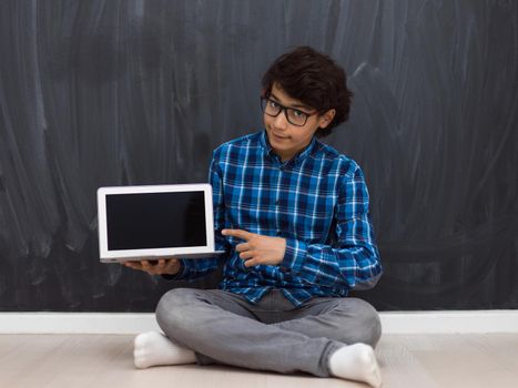 Arab teenagers using laptops to work on homework and watch online education while staying at home cause coronavirus pandemic quarantine. High quality photo