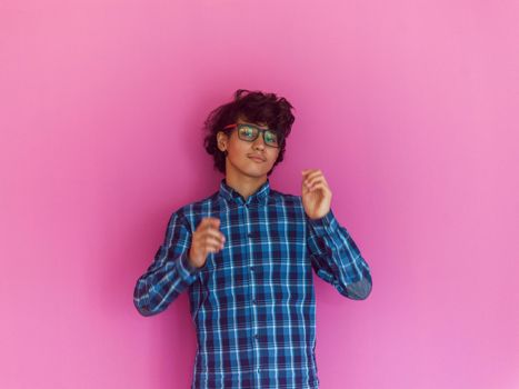 Arabic Teenage Boy Wearing Headphones And Listening To Music pink background. High quality photo