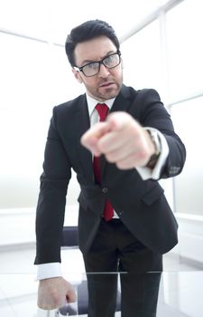 strict businessman pointing finger at you while standing in his office.business concept