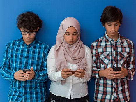 Arab teenagers group using smartphones for social media networking and sharing information for online education. High quality photo. Selective focus