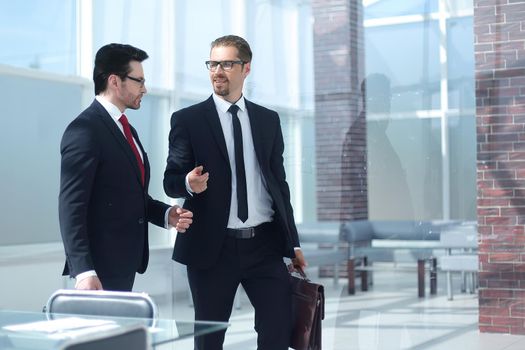 two smiling businessman walking in the office hall.photo with copy space